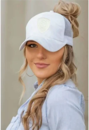 A woman with long blonde hair wearing a white hat.